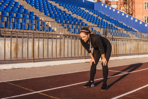 istock woman resting after running at the stadium 1279118555