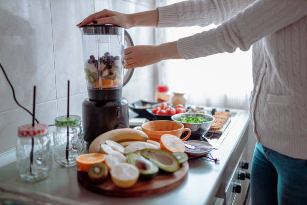 istock Woman making fruit smoothie in the kitchen at home 1279119713