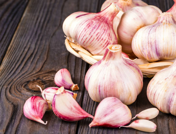 istock Garlic cloves and garlic bulb on a old wooden table 1279120845