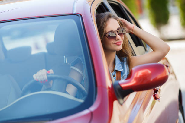 istock Happy woman driving a red compact car 1279122330