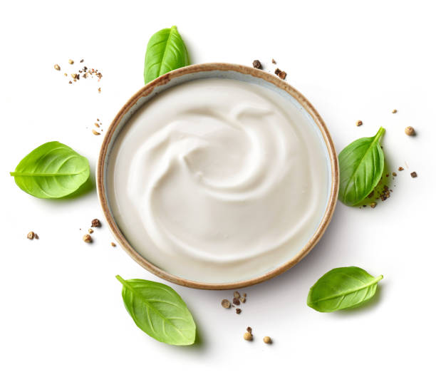 bowl of whipped yogurt cream bowl of whipped yogurt cream and basil leaves isolated on white background, top view mayonnaise photos stock pictures, royalty-free photos & images