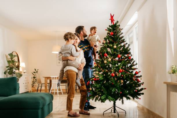 istock Young family decorating their christmas tree 1279125497