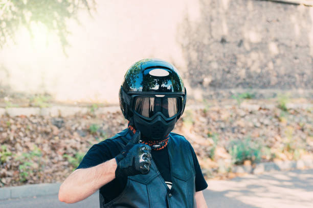 istock biker with black helmet leather vest and thumb up 1279128686