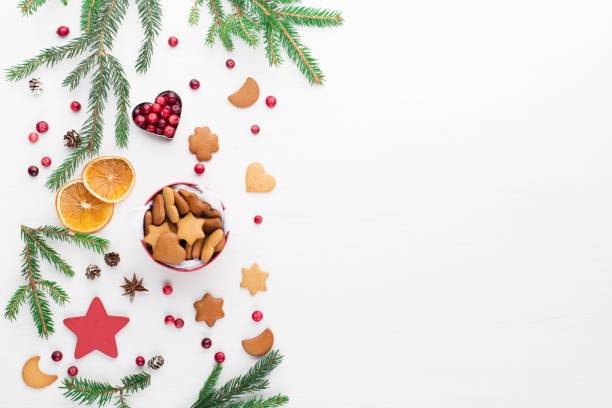 istock Christmas Decorative Border made of Festive Elements, gingerbread cookies, cranberries on white wooden background. 1279128779
