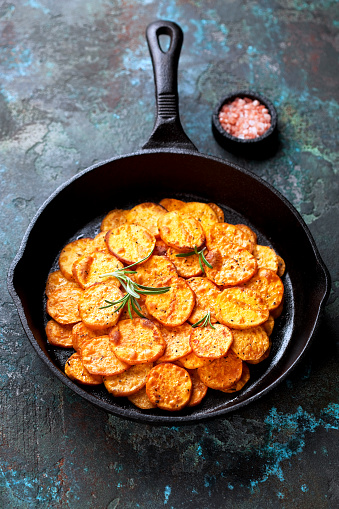 Roasted sweet potato  in a cast iron pan, selective focus