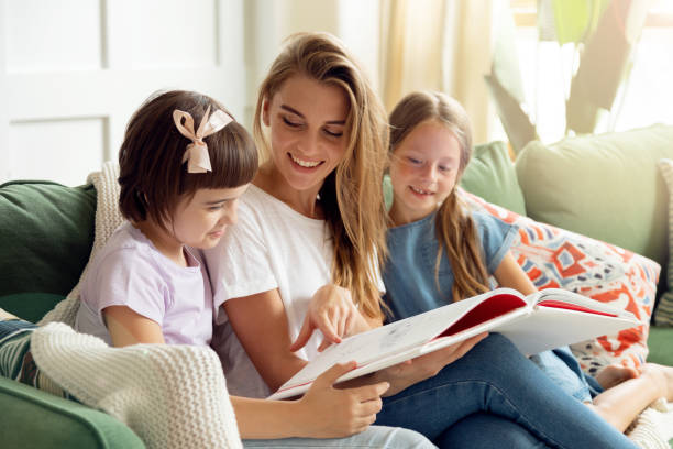istock mother reading a book to their children 1279138096