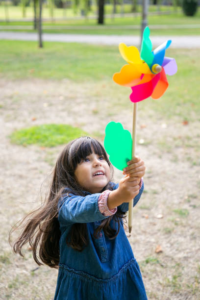 istock Cheerful black haired girl playing in park 1279139989