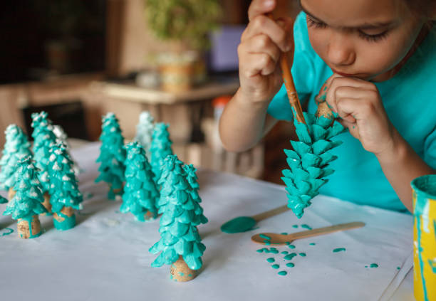 regalos de artesanía diy y decoración de navidad. chica colorante cono como si fuera pino, ser verde - land craft fotografías e imágenes de stock