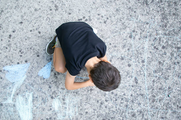 istock Black haired little boy sitting and drawing 1279141365