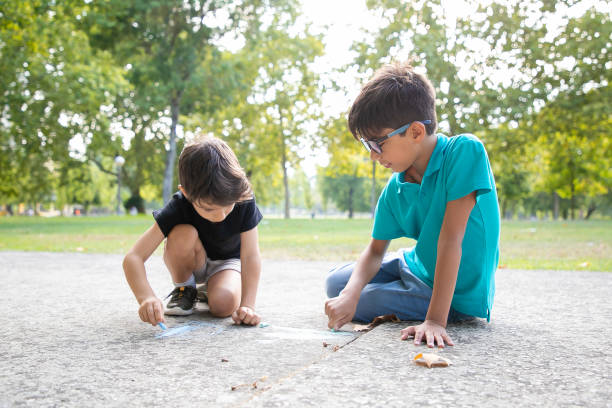 istock Focused black haired boys sitting and drawing 1279143307