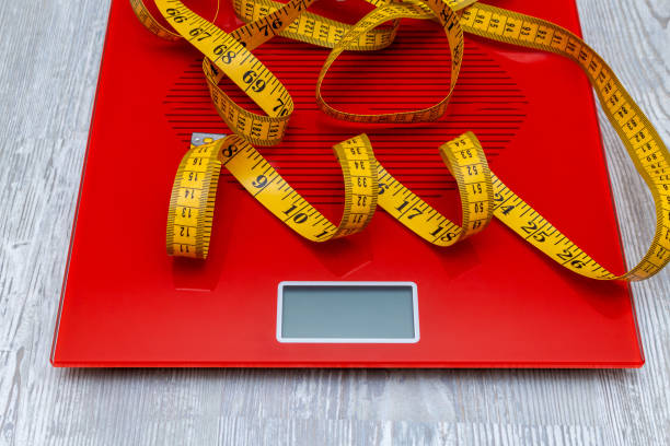 istock digital electronic scale with measuring tape. diet, slimming concept. 1279143745