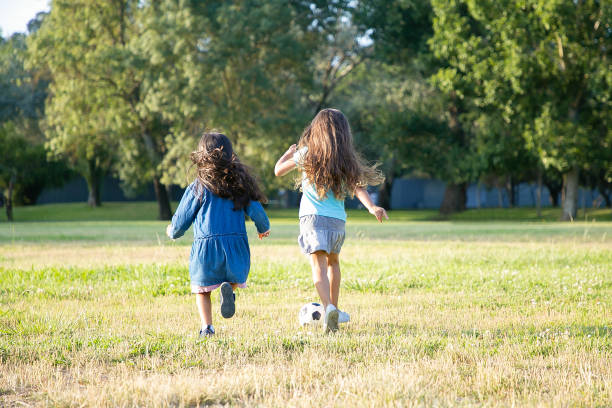 istock Active black haired girls running for soccer ball 1279143837