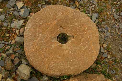 The ancient stone mill fragment. vintage wheat grain grinder, close-up. Farming and agriculture concept