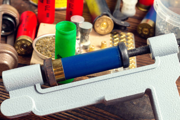 istock Shotgun shells reloading process with special reload equipment. Powder, bullets, fraction, shells, buckshot on the wooden background. 1279144654