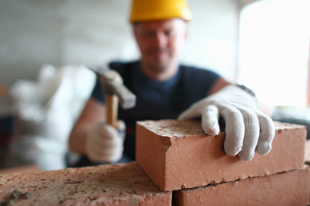 istock Male worker in gloves building brick wall 1279144741
