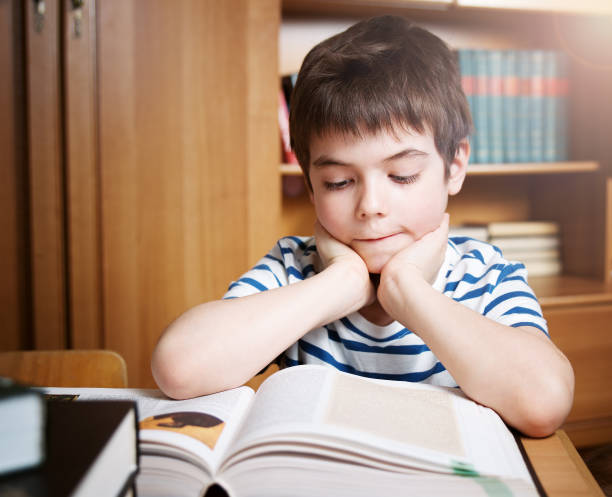 istock Seven years old child reading a book 1279145654
