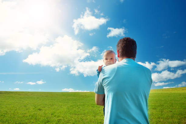 istock Little baby with father standing in the field 1279146464