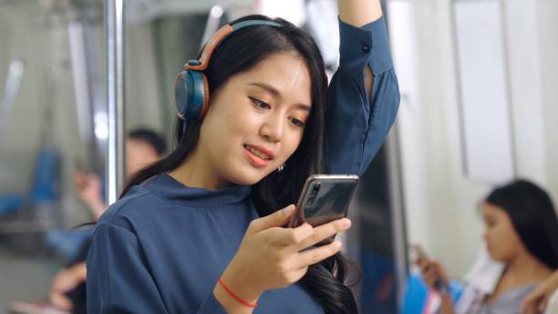 istock Young woman using mobile phone on public train 1279149843