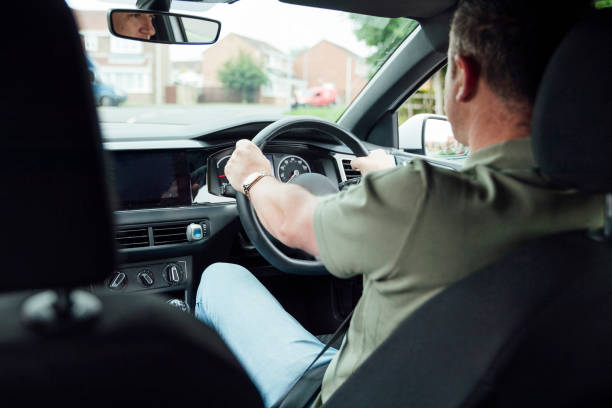 In The Drivers Seat A shot of a 40yr old Caucasian male's hands on the driver's steering wheel. taxi driver stock pictures, royalty-free photos & images