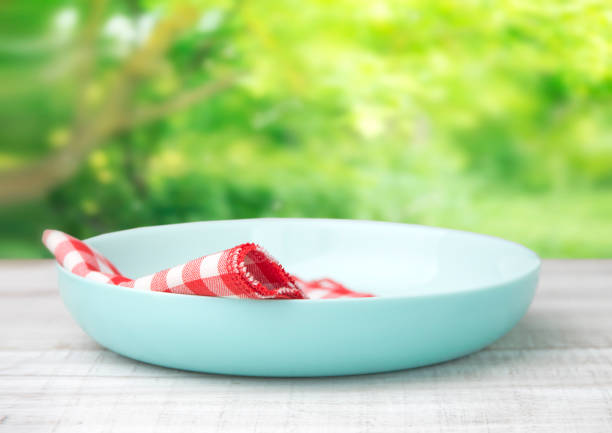Turquoise plate with checkered red napkin on wooden white table