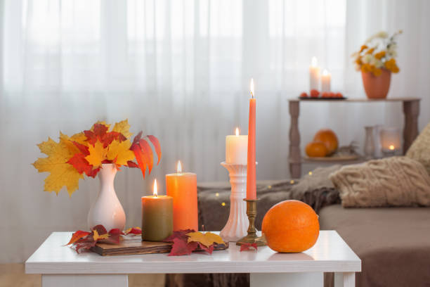 istock burning candles with autumn decor on white table at home 1279159127
