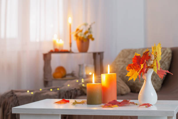 istock burning candles with autumn decor on white table at home 1279159131