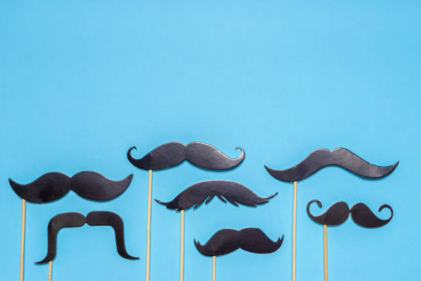 istock Various black photo booth props moustaches of different shape on blue background. Greeting card for father's day or men's health awareness month campaign concept. Flat lay, space for text, mock up 1279162151