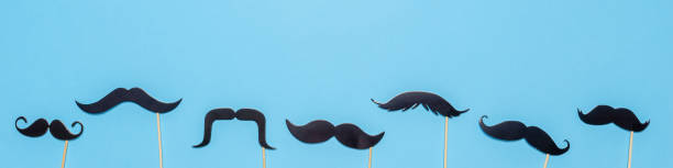 istock Various black photo booth props moustaches of different shape on blue background. Greeting card for father's day or men's health awareness month campaign concept. Flat lay, banner 1279162209