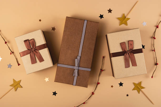 istock Three Christmas gift boxes on a neutral background among decorations 1279166348