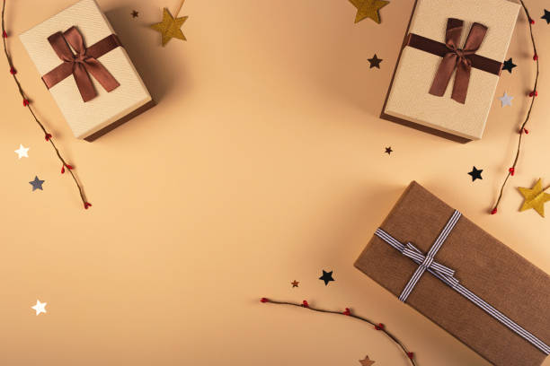 Three Christmas gift boxes on a neutral background among decorations