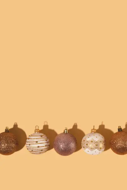 Minimalistic round Christmas balls in white and gold on a neutral background.