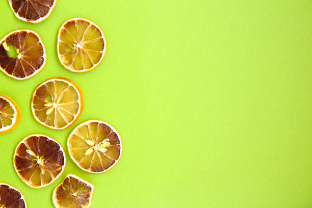 istock Slices of dried lemon on light green background 1279167722