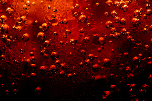 Close up view of the ice cubes in cola background ,Detail of Cold Bubbly Carbonated Soft Drink with Ice