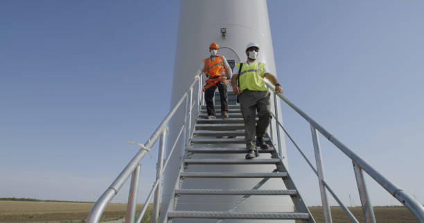 istock Engineers in masks walking away windmill 1279171145