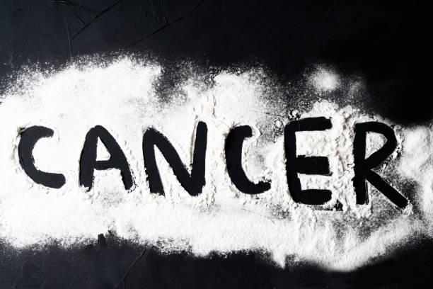 istock CANCER word on black cement background. 1279174015