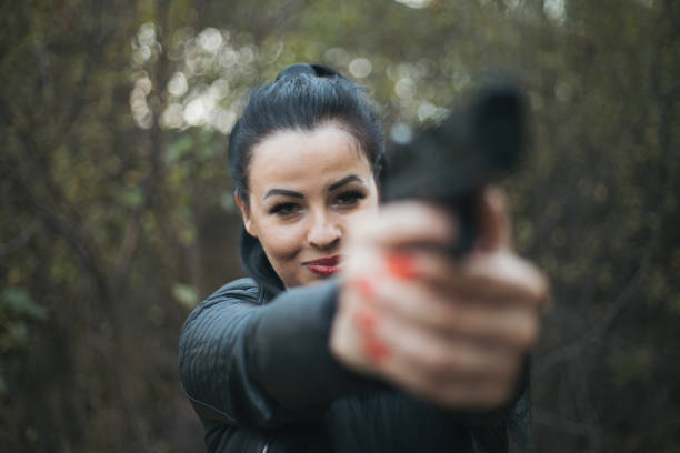 istock Sexy woman holding gun 1279174344
