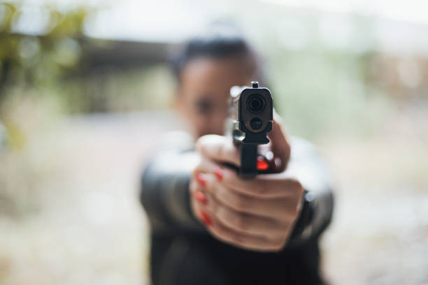 istock Sexy woman holding gun 1279174435