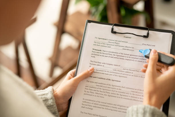 istock Hands of young female applicant with blue highlighter looking through contract 1279176276