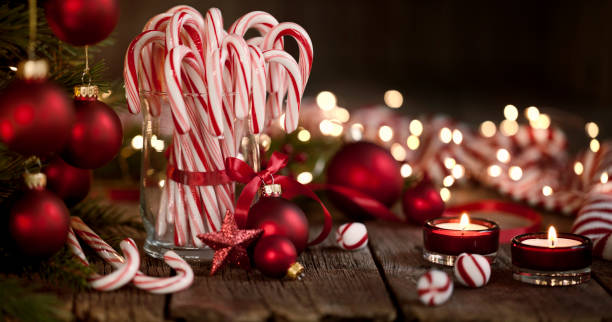 Candy Canes and Bright Christmas Lights on an Old Wood Background Candy Canes and Bright Christmas Lights on an Old Wood Background peppermints stock pictures, royalty-free photos & images