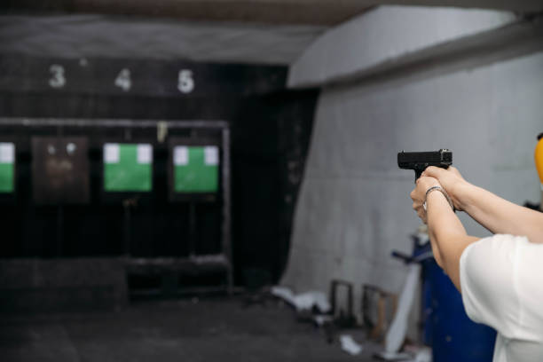 alcance de tiro. vista trasera de la mujer disparando con pistola en el campo de tiro - gun women handgun armed forces fotografías e imágenes de stock