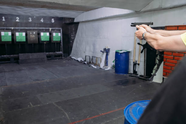 istock Shooting range. Rear view of men shooting with gun in shooting range 1279177483
