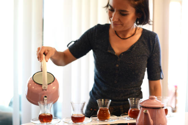 istock Woman pouring turkish tea in kitchen 1279177737