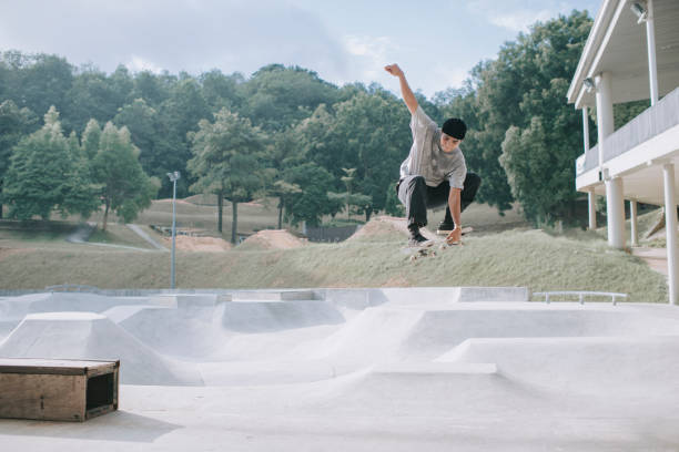 skateboarder asiatique dans l’action en plein air x jeux - ollie photos et images de collection