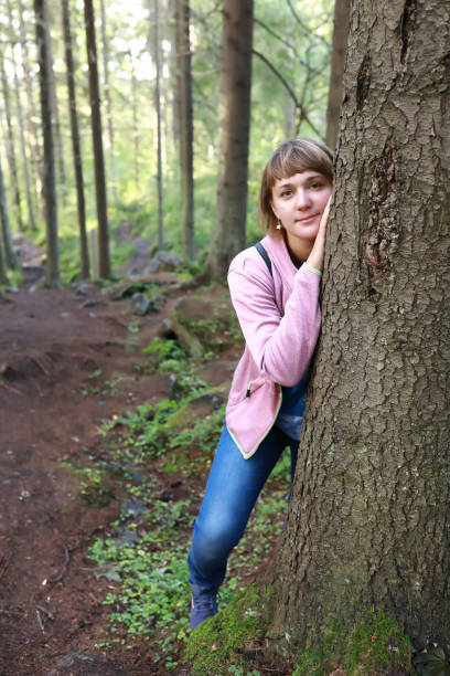 istock Woman behind pine in forest 1279180530