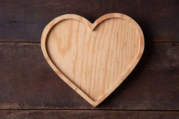 Photo of heart shape  wood tray on textured wood