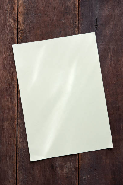 istock Blank beige sticky note isolated on wood background 1279184381