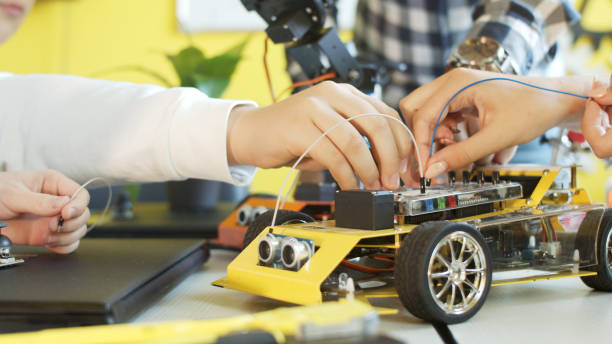 istock Crop teenager playing with modern robot in class 1279184407