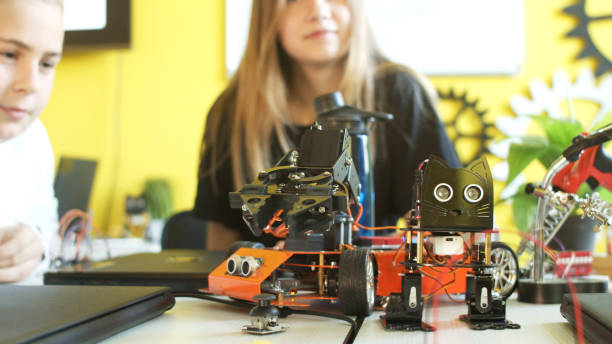 istock Crop teenager playing with modern robot in class 1279184744