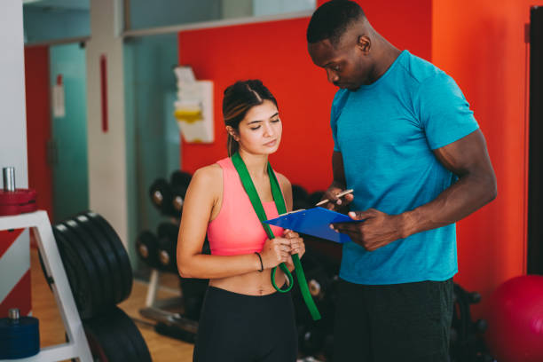 istock Sports training in the gym with personal trainer 1279189325