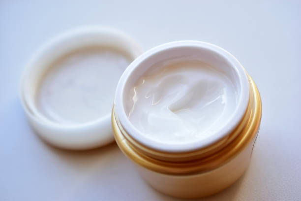 istock Yellow and white jar with white cosmetic cream 1279189338
